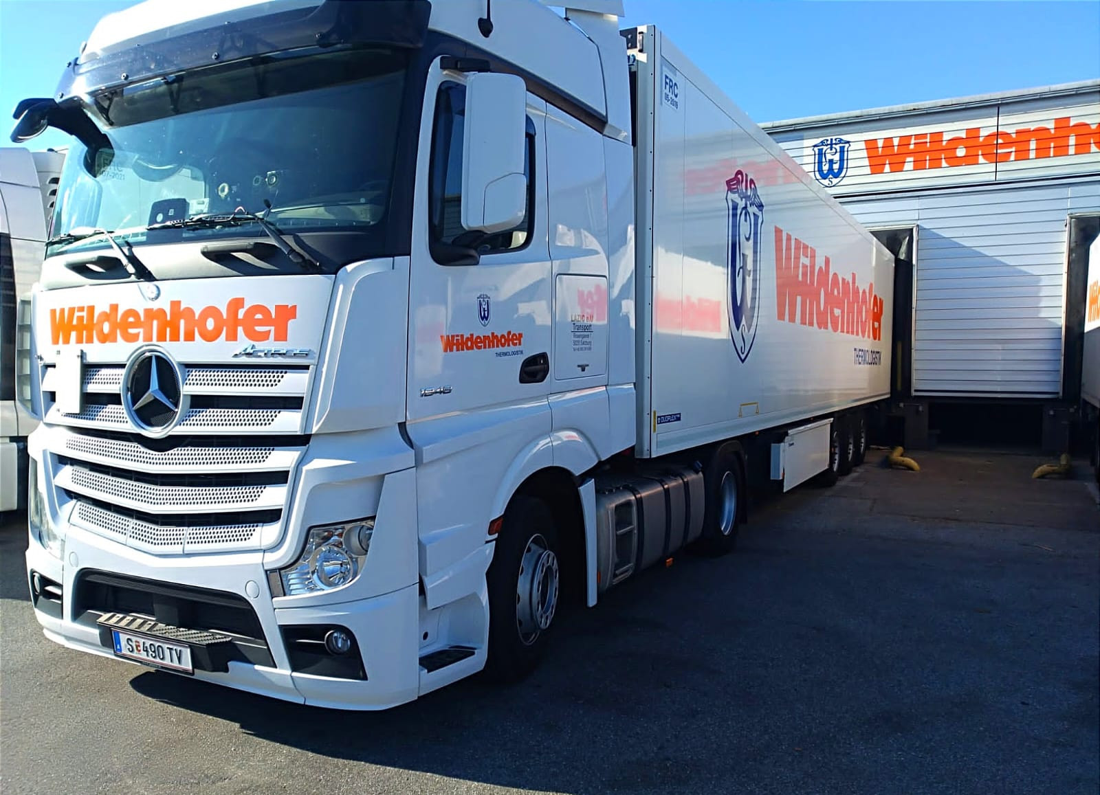 Ein LKW der Spedition Wildenhofer steht angedockt in einer Ladebucht.