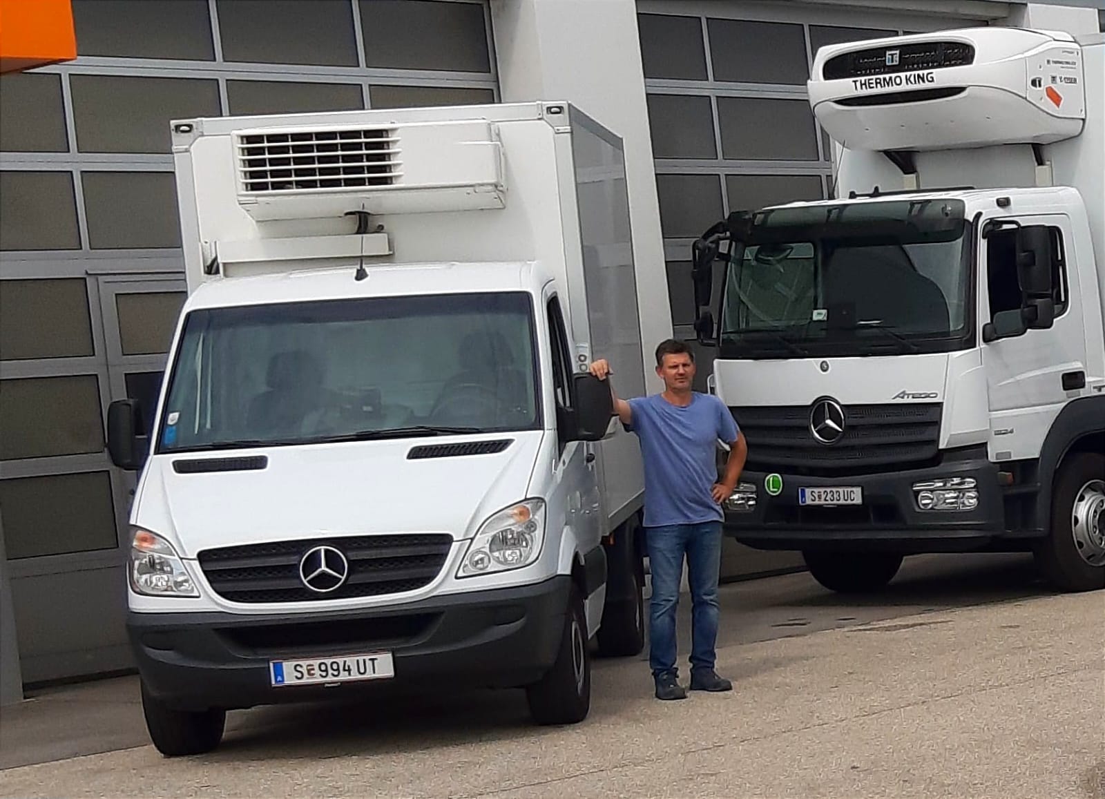 Radomir Lazic steht an einem Lieferwagen. Im Hintergrund ist ebenfalls ein LKW zu sehen.